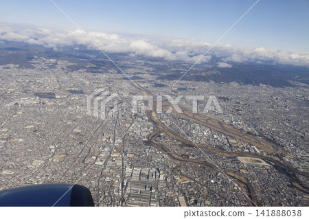 從飛機上拍攝的廣大城市和遠處山脈的空拍照片。 從飛機上拍攝的廣大城市和遠處山脈的空拍照片。 141888038