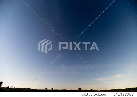 Milky Way Galaxy shining brightly over a serene landscape at dusk Milky Way Galaxy shining brightly over a serene landscape at dusk 141888398