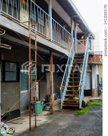 Exterior of an old two-story apartment building and iron staircase Exterior of an old two-story apartment building and iron staircase 141888576