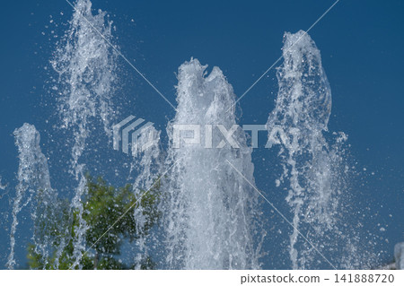 Dancing water jets sparkle under a blue sky bringing joy to passersby on a sunny day at the park Dancing water jets sparkle under a blue sky bringing joy to passersby on a sunny day at the park 141888720