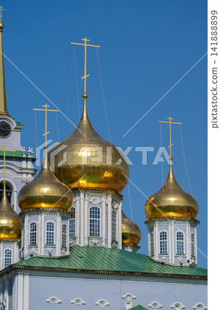 Glistening domes of the Cathedral of the Assumption shine under the clear blue sky in Tula Russia during a bright sunny day Glistening domes of the Cathedral of the Assumption shine under the clear blue sky in Tula Russia during a bright sunny day 141888899