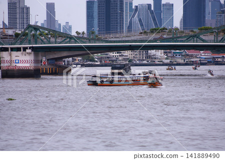 View of motorboats and passenger boats navigating the Chao Phraya River near Memorial Bridge View of motorboats and passenger boats navigating the Chao Phraya River near Memorial Bridge 141889490