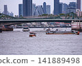 View of motorboats and passenger boats navigating the Chao Phraya River near Memorial Bridge 141889498