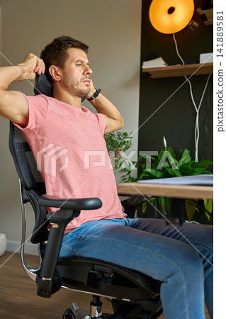 Man adjusting headrest on ergonomic office chair Man adjusting headrest on ergonomic office chair 141889581