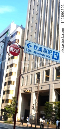 Signposts to Akihabara Station and a cityscape shining against the blue sky. Signposts to Akihabara Station and a cityscape shining against the blue sky. 141890291