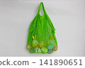 There is a green net with Easter eggs with bunny ears hanging on the wall. Easter concept 141890651