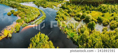 Aerial view. Green forest, meadow and river marsh landscape in summer. Top view of european nature from high attitude in summertime. Bird's eye view. Belarus Aerial view. Green forest, meadow and river marsh landscape in summer. Top view of european nature from high attitude in summertime. Bird's eye view. Belarus 141891591