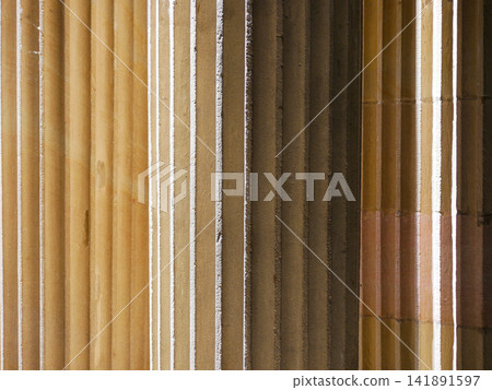 Close-up architectural background detail of classical fluted columns with warm sandstone texture, evoking ancient Greek and Roman architecture, antiquity, history, heritage and classical design. Close-up architectural background detail of classical fluted columns with warm sandstone texture, evoking ancient Greek and Roman architecture, antiquity, history, heritage and classical design. 141891597