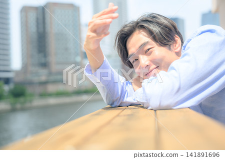 一位微笑的年輕人抬頭望向天空。 一位微笑的年輕人抬頭望向天空。 141891696