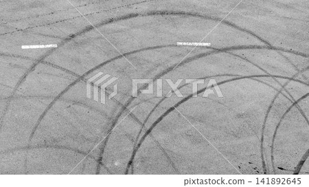 Aerial view tire mark on the asphalt road race track, Car tire mark burnout texture and background, Car tire mark from car skid mark, Car tire on asphalt road race track. Aerial view tire mark on the asphalt road race track, Car tire mark burnout texture and background, Car tire mark from car skid mark, Car tire on asphalt road race track. 141892645