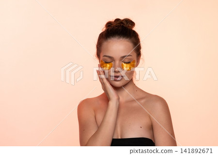 Woman enjoying under eye patches for hydration, skincare and wellness, nurturing beautiful facial skin Woman enjoying under eye patches for hydration, skincare and wellness, nurturing beautiful facial skin 141892671
