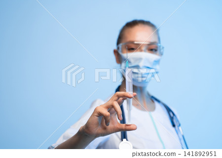 Healthcare professional holding a syringe with needle, preparing an injection for vaccination or treatment Healthcare professional holding a syringe with needle, preparing an injection for vaccination or treatment 141892951
