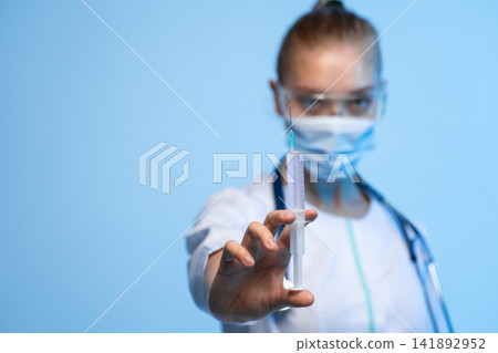 Healthcare professional holding syringe with vaccine, preventing disease, immunization and public health concept Healthcare professional holding syringe with vaccine, preventing disease, immunization and public health concept 141892952