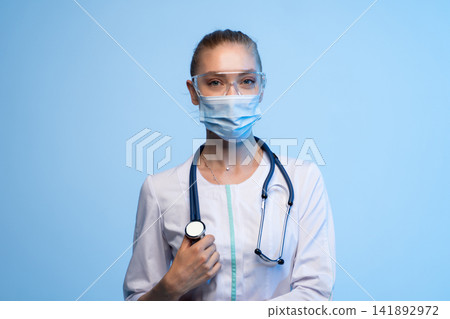 Female doctor wearing mask, goggles, and stethoscope for healthcare protection 141892972