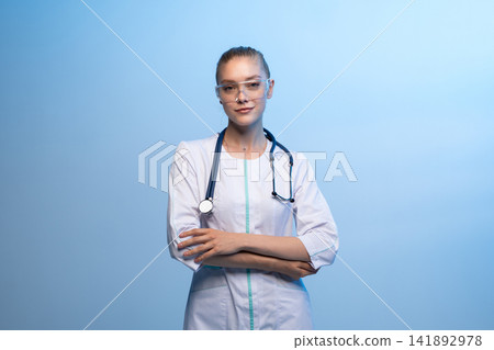 Female doctor wearing safety goggles and stethoscope Female doctor wearing safety goggles and stethoscope 141892978