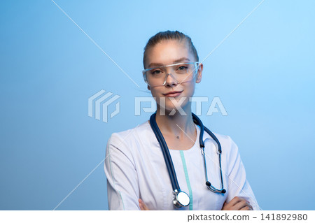 Female doctor wearing safety glasses and stethoscope Female doctor wearing safety glasses and stethoscope 141892980