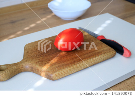 Red Tomato with Knife on Wooden Cutting Board for Culinary Food Preparation Red Tomato with Knife on Wooden Cutting Board for Culinary Food Preparation 141893078