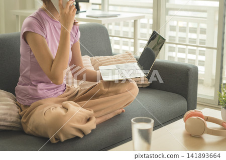 Young Asian Woman Working Online, Relaxing and Practicing Self Care During Daily Life at Home Young Asian Woman Working Online, Relaxing and Practicing Self Care During Daily Life at Home 141893664