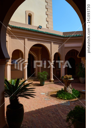Sunlit courtyard with arches and Moroccan architecture in Tangier, Morocco 141893730