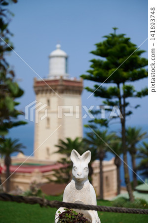 Rabbit statue in coastal garden with lighthouse backdrop in Tangier Morocco Rabbit statue in coastal garden with lighthouse backdrop in Tangier Morocco 141893748
