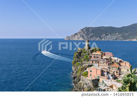 Vernazza within Liguria, Italy, including sweeping white boat wake toward the tower Vernazza within Liguria, Italy, including sweeping white boat wake toward the tower 141893855