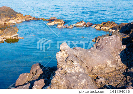 peaceful rock reflection in the sea water. calm summer vacation at the black sea. sunny weather peaceful rock reflection in the sea water. calm summer vacation at the black sea. sunny weather 141894026