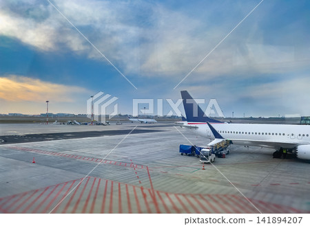 Airplane Wing and Engine on Airport Runway at Sunset View 141894207