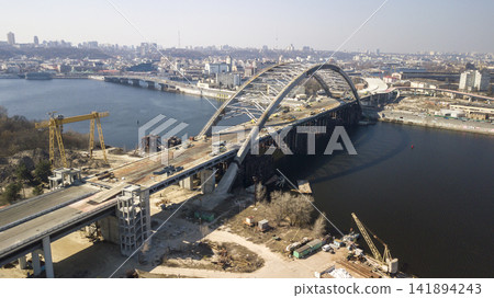 View top of the construction of the Podolsk-Voskresensky bridge in Kiev Ukraine March 2020 from a flight height View top of the construction of the Podolsk-Voskresensky bridge in Kiev Ukraine March 2020 from a flight height 141894243