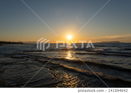 Golden sunset over ocean waves with sparkling sun path on water Golden sunset over ocean waves with sparkling sun path on water 141894642