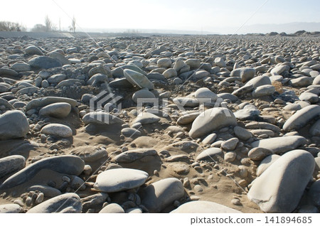 Rocky Riverbed Landscape with Smooth Pebbles and Dry Terrain Rocky Riverbed Landscape with Smooth Pebbles and Dry Terrain 141894685