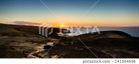 Sunset Coastline Over Volcanic Cliffs and Calm Ocean Sunset Coastline Over Volcanic Cliffs and Calm Ocean 141894696