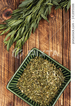 Green tarragon herb with dried leaves in bowl Green tarragon herb with dried leaves in bowl 141895086