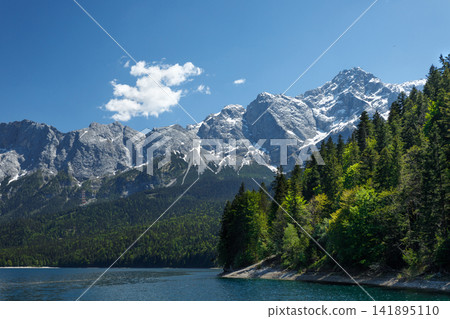 Travel landscape of Eibsee lake and Zugspitze mountain peak in Alps in Bavaria, Germany, scenic summer nature panorama with forest und mountains. Alpine landscape Travel landscape of Eibsee lake and Zugspitze mountain peak in Alps in Bavaria, Germany, scenic summer nature panorama with forest und mountains. Alpine landscape 141895110