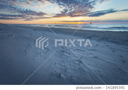 Sandy beach of the Baltic Sea with sunset 141895391