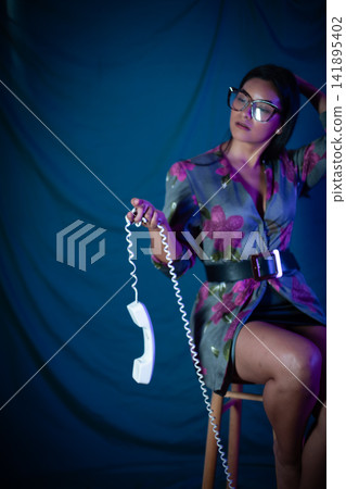Woman holding phone receiver communicating vintage style Woman holding phone receiver communicating vintage style 141895402
