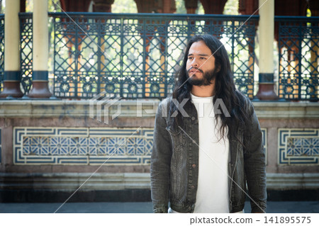 Young man looking away at moorish kiosk Young man looking away at moorish kiosk 141895575