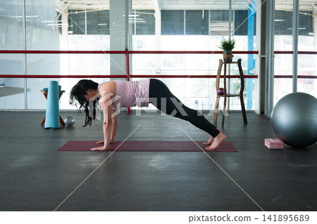 Woman exercising plank pose on yoga mat indoors Woman exercising plank pose on yoga mat indoors 141895689