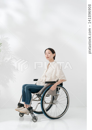 一位四十多歲的女子坐在輪椅上。 一位四十多歲的女子坐在輪椅上。 141896908