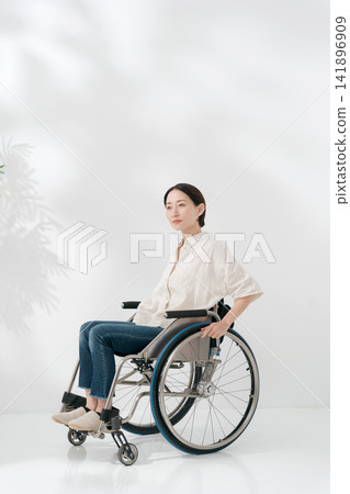 一位四十多歲的女子坐在輪椅上。 一位四十多歲的女子坐在輪椅上。 141896909