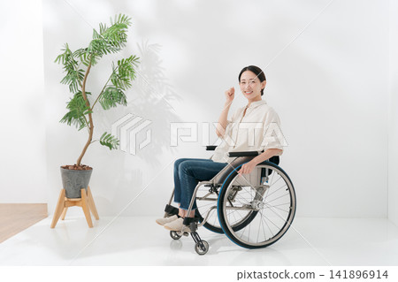 一位四十多歲的輪椅使用者擺出勝利姿勢。 141896914