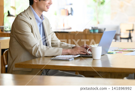 A man working on a computer A man working on a computer 141896992