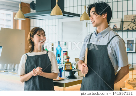The male and female shop staff spoke with smiles. The male and female shop staff spoke with smiles. 141897131