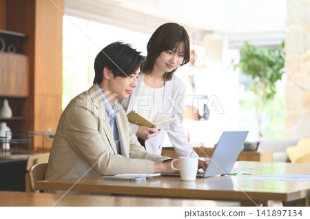一群男女圍坐在電腦前開會。 141897134