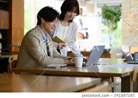一男一女一邊看著電腦螢幕一邊討論著什麼。 一男一女一邊看著電腦螢幕一邊討論著什麼。 141897165