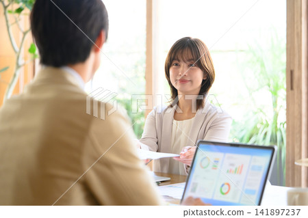 一位女士在商務會議上遞交文件。 141897237