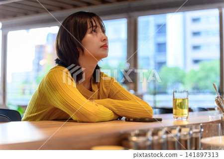 A woman deep in thought at the counter A woman deep in thought at the counter 141897313