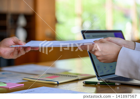 The hands of a business person handing over documents The hands of a business person handing over documents 141897567