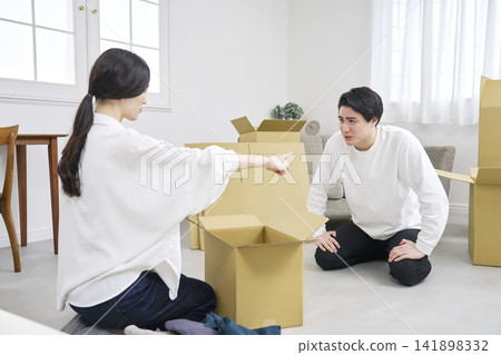 A couple argues during a move, with the man apologizing and the woman getting angry. A couple argues during a move, with the man apologizing and the woman getting angry. 141898332