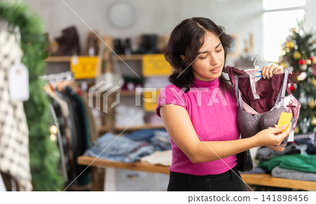 Asian woman choosing a bra on the background of the Christmas tree Asian woman choosing a bra on the background of the Christmas tree 141898456