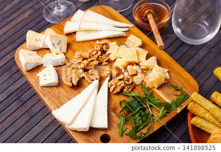 Varieties of cheese sliced and served with honey 141898525